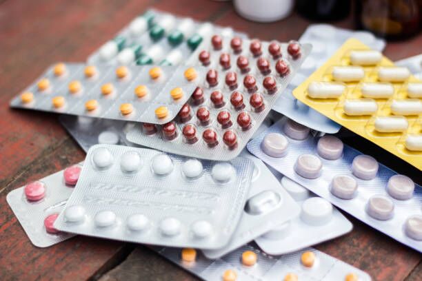 Medications and tablets on a wooden texture table